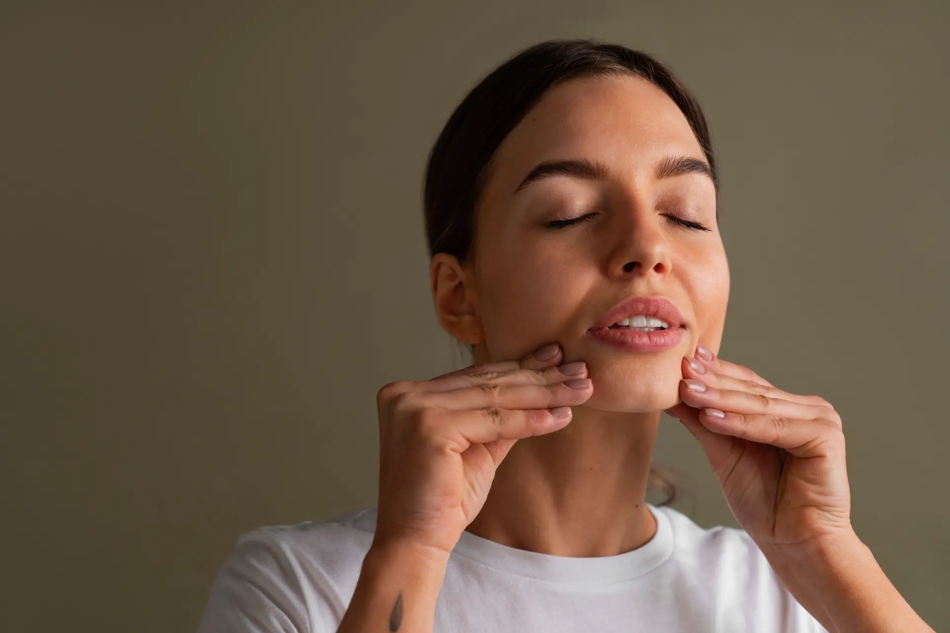 Portret i një gruaje të re duke praktikuar facial yoga — Tria by Lex, Durrës